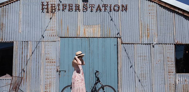 heifer-station-Hero.jpg Woman arriving on bike to Heifer Station Wines in Orange